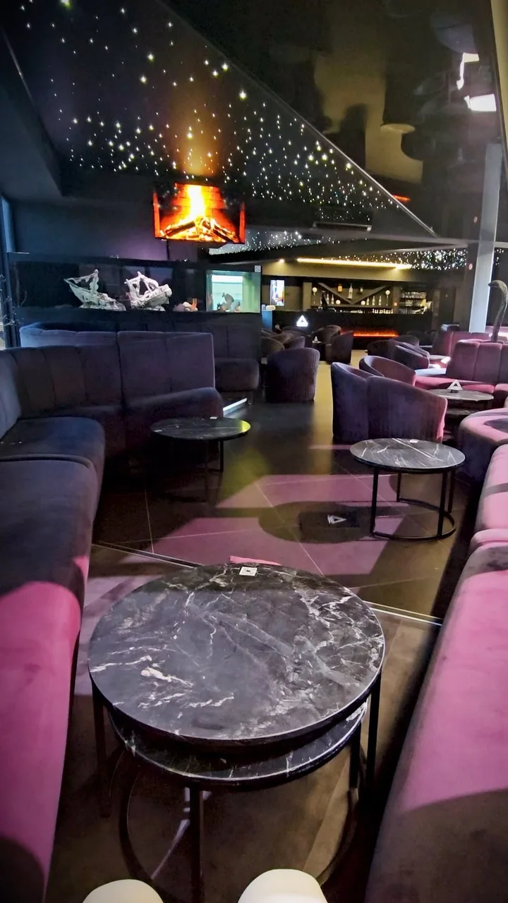 Fauteuils en velours, tables en marbre et plafond étoilé à l’intérieur du Building